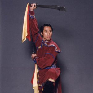 Master (Shifu) Charles Lin in a high stance weilding two sabers